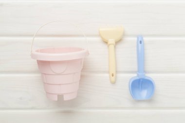 Ahşap arka planda kumla oynamak için sevimli oyuncaklar.