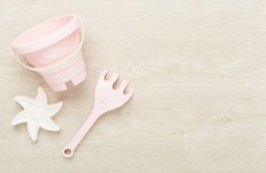 Ahşap arka planda kumla oynamak için sevimli oyuncaklar.