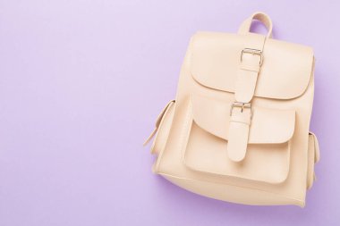 Renkli arka planda bej renkli sırt çantası, üst görünüm.