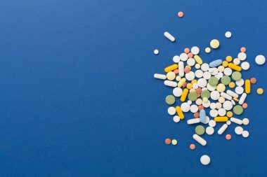 Farklı ilaç ve kapsüller. Renkli arka plan, üst görünüm.