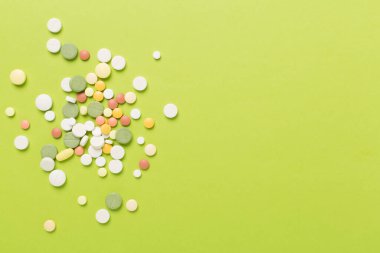 Farklı ilaç ve kapsüller. Renkli arka plan, üst görünüm.