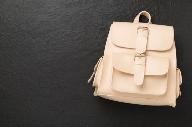 Beton zemin üzerinde bej renkli stil sırt çantası, üst görünüm.