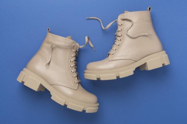 Renk arkaplanında bej renkli moda çizmeler, üst görünüm.