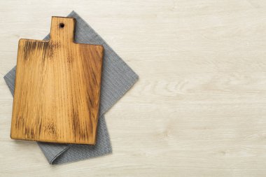 Tahta kesme tahtası, ahşap zemin üzerinde peçete, üst görünüm