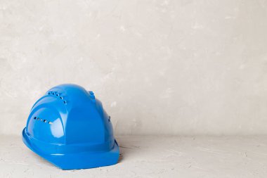 Beton arka planda mavi miğfer