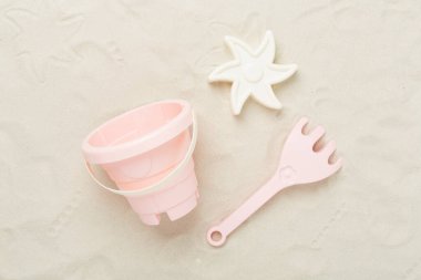 Kum arka planda oynamak için sevimli oyuncaklar, üst görünüm