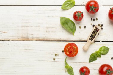 Taze domates, fesleğen, deniz tuzu ve ahşap arka planda baharatlar, üst manzara.