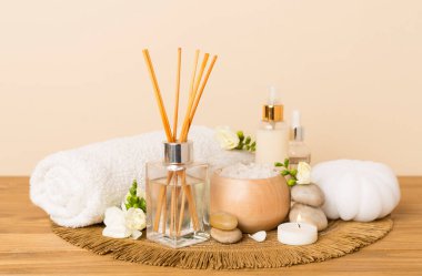 Tahta masa üzerinde frezya çiçeği ve aroma yayıcı içeren spa kompozisyonu