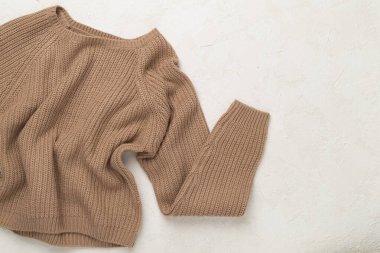 Beton arka planda kahverengi süveter, üst manzara