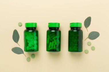 İlaç şişesi ve yeşil yapraklı arka plan, üst görünüm