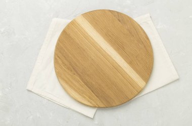 Beton arka planda peçeteyle kesme tahtası, üst görünüm