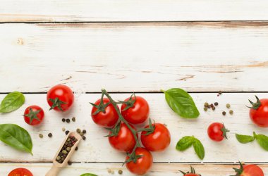 Taze domates, fesleğen, deniz tuzu ve ahşap arka planda baharatlar, üst manzara.