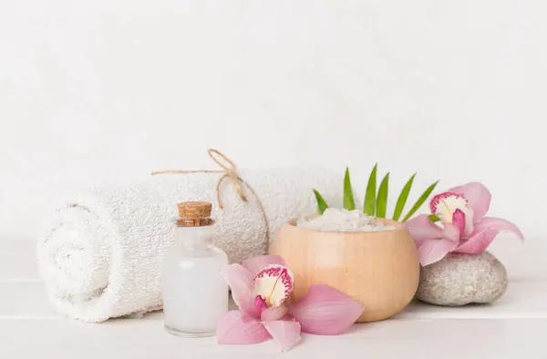 Orkideli kompozisyon, ahşap masadaki spa ürünleri