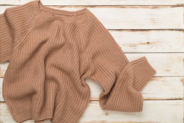 Kahverengi süveter ahşap arka planda, üst manzara