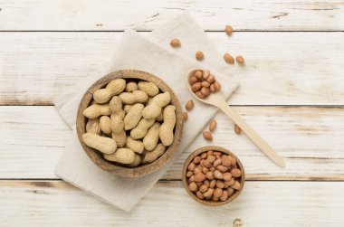 Ahşap arka planda soyulmuş ve soyulmamış fıstıklar.