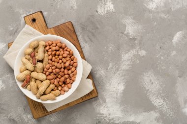 Soyulmuş ve soyulmamış fıstıklar beton arka planda, üst manzara