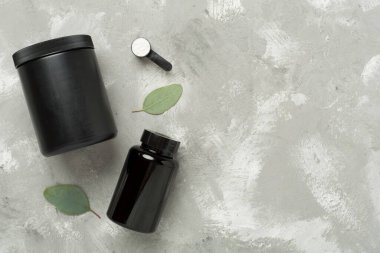 Beton zemin üzerinde protein tozu olan kavanozlar, üst manzara. Spor beslenme konsepti