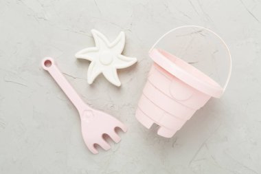 Beton arka planda kumla oynamak için sevimli oyuncaklar.