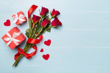Ahşap arka planda hediye kutusu olan kırmızı gül çiçekleri, üst, manzara. Sevgililer Günü konsepti