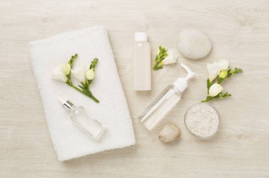 Tahta arka planda kaplıca ürünleri ve çiçeklerle yatıyordu