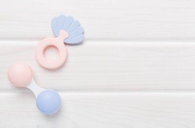 Ahşap arka planda renkli bebek çıngırakları ve oyuncakları, üst manzara
