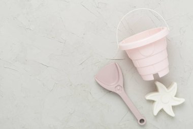 Beton arka planda kumla oynamak için sevimli oyuncaklar.