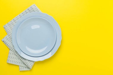 Renk arkaplanında masa örtüsü olan boş tabak, üst görünüm