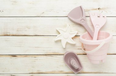 Ahşap arka planda kumla oynamak için sevimli oyuncaklar.