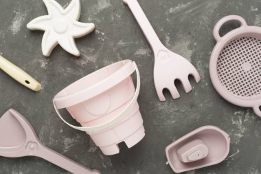 Beton arka planda kumla oynamak için sevimli oyuncaklar.