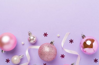 Renkli arka planda dekoru olan pembe noel topları, üst görünüm