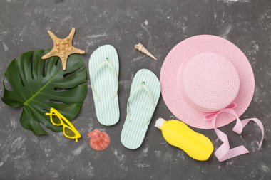 Beton arka planda renkli plaj aksesuarlarıyla yatıyordu. Tatil kavramı