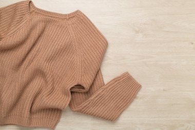 Kahverengi süveter ahşap arka planda, üst manzara