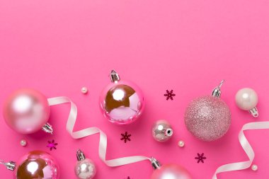 Renkli arka planda dekoru olan pembe noel topları, üst görünüm