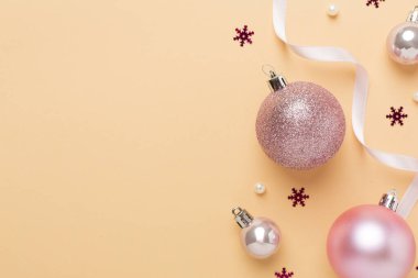 Renkli arka planda dekoru olan pembe noel topları, üst görünüm