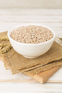 Tahta masada büyülenmiş tahıl ve kulaklarla kase