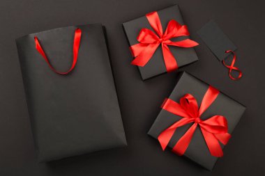 Siyah alışveriş çantası ve renkli arka planda hediye kutuları. En iyi görüntü. Kara Cuma konsepti.