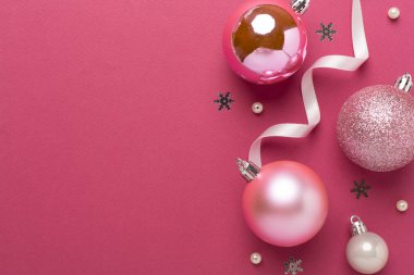 Renkli arka planda dekoru olan pembe noel topları, üst görünüm