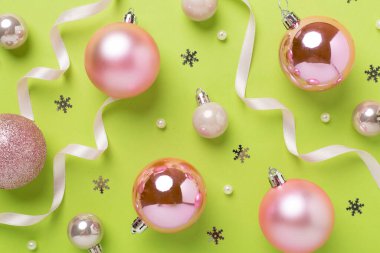 Renkli arka planda dekoru olan pembe noel topları, üst görünüm