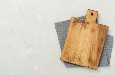 Beton arka planda peçeteyle kesme tahtası, üst görünüm