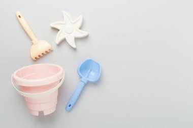 Renkli arka planda kumla oynamak için sevimli oyuncaklar, üst görünüm