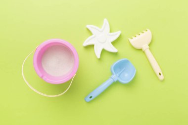 Renkli arka planda kumla oynamak için sevimli oyuncaklar, üst görünüm