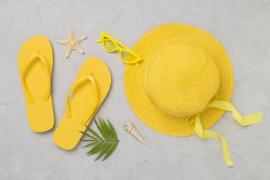 Beton arka planda sarı yazlık kıyafetlerle yatıyordu. Tatil kavramı