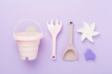 Renkli arka planda kumla oynamak için sevimli oyuncaklar, üst görünüm