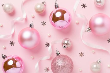 Renkli arka planda dekoru olan pembe noel topları, üst görünüm