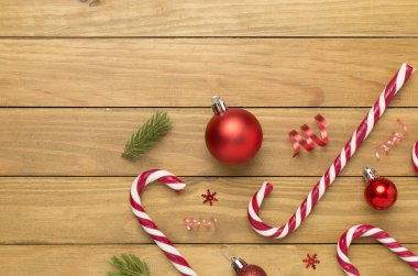 Ahşap zemin üzerinde lolipoplar olan Noel kompozisyonu, üst manzara