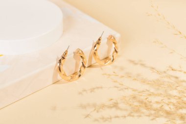 Arkaplanda dekoru olan altın küpeler