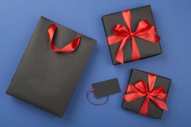 Siyah alışveriş çantası ve renkli arka planda hediye kutuları. En iyi görüntü. Kara Cuma konsepti.