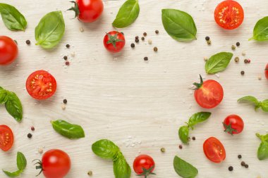 Taze domates, fesleğen, deniz tuzu ve ahşap arka planda baharatlar, üst manzara.