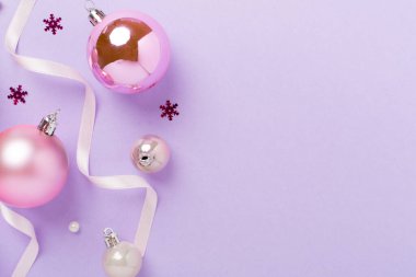 Renkli arka planda dekoru olan pembe noel topları, üst görünüm