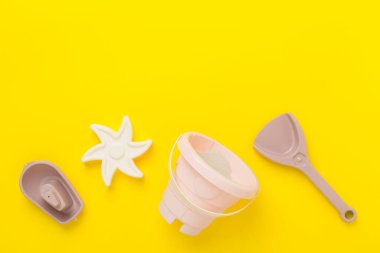 Renkli arka planda kumla oynamak için sevimli oyuncaklar, üst görünüm